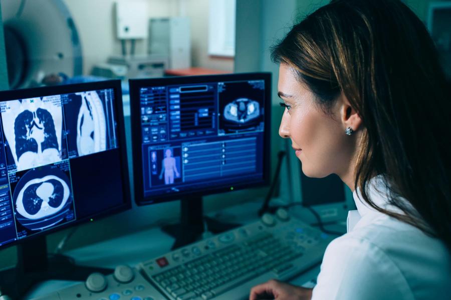 a provider looking at computer monitors of imaging results